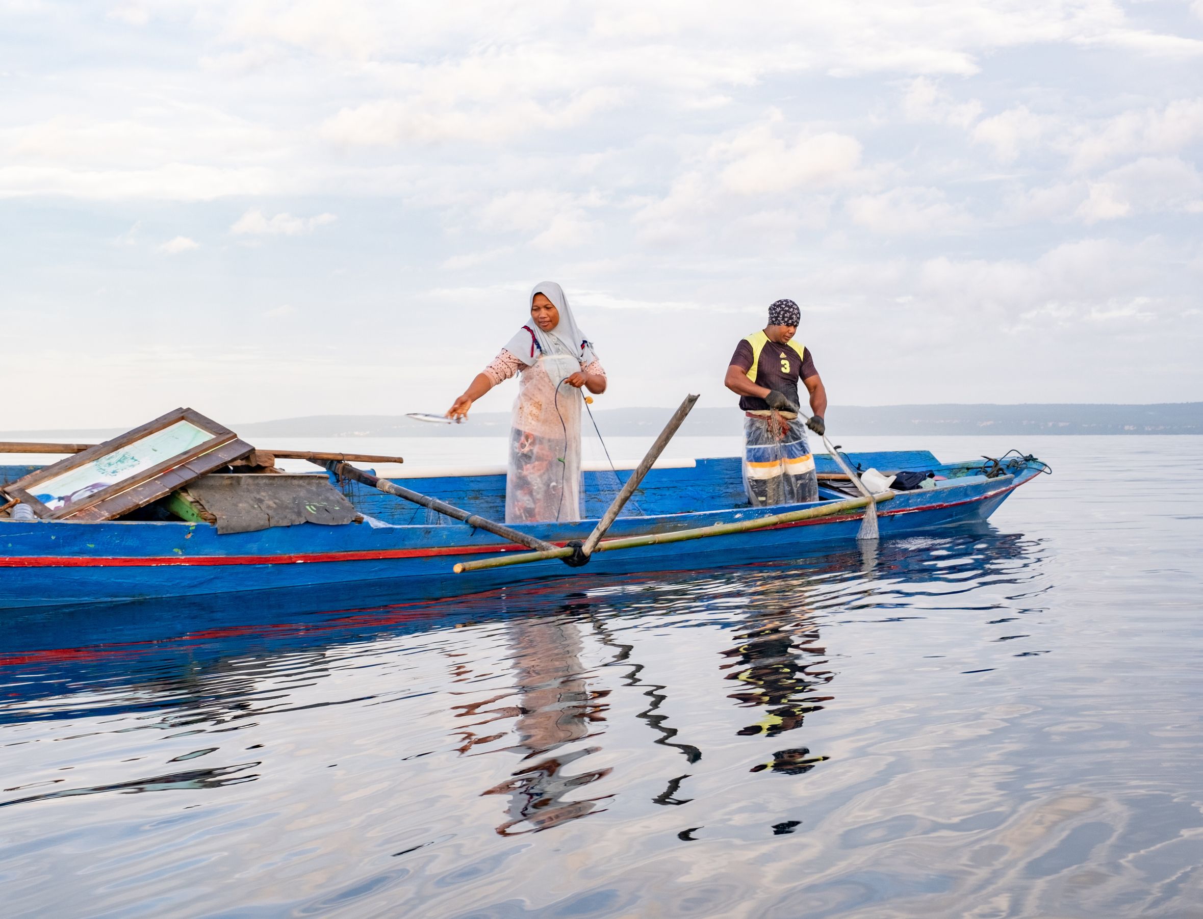 (Left to right) Rustian and Sugianto, wife and husband fishers, net fishing off the coast of their community, Pasi Kolaga. Southeast Sulawesi, Indonesia.