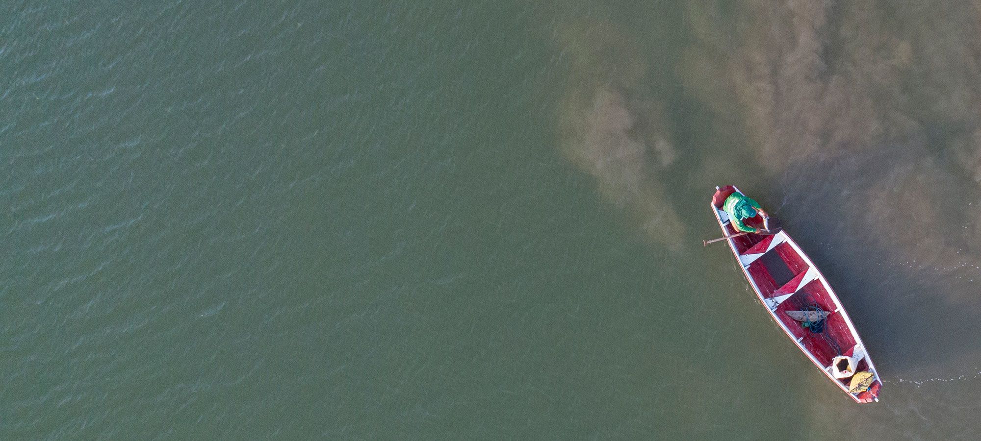 Aerial photo of a boat with a fisherman on the Mocajuba River in Brazil.