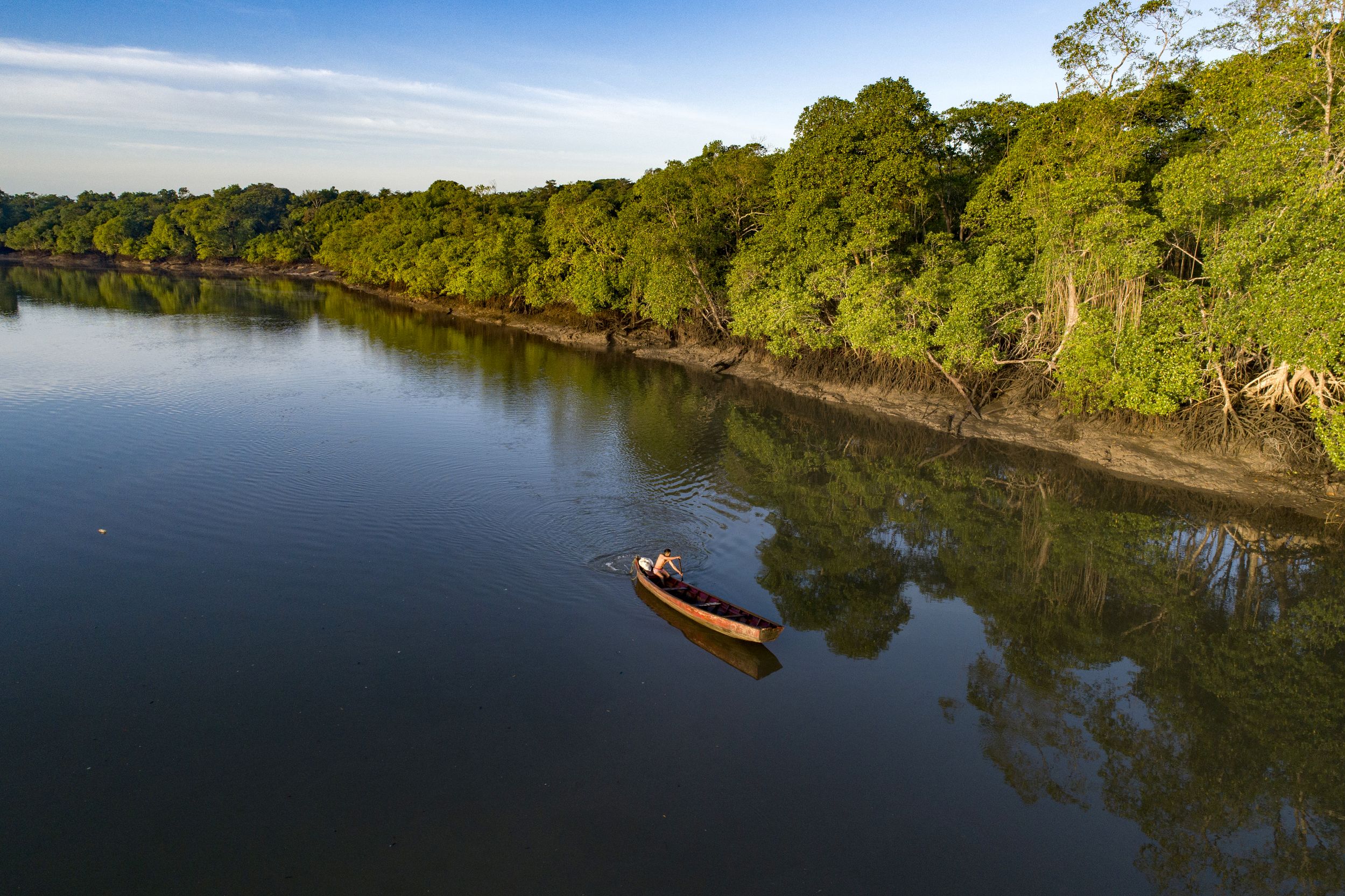 Fisherman on a boat floating on The Mocajuba River in the RESEX São João da Ponta.