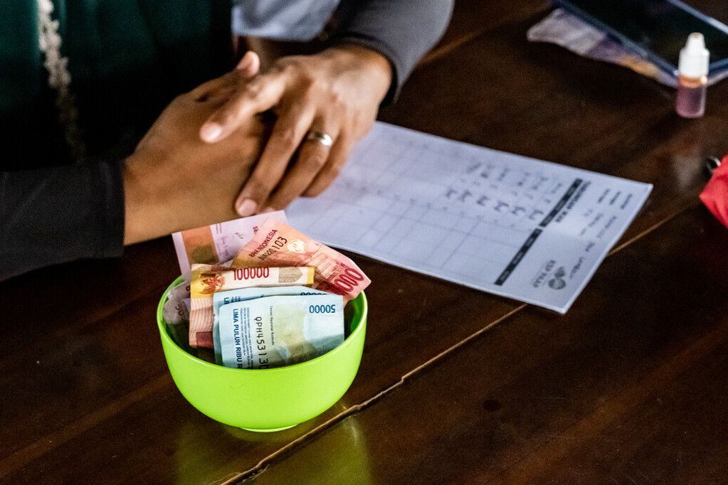 Photo of a bowl with colorful rupiah in it from a local savings clu in Indonesia.